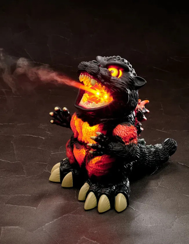 光を発するゴジラのフィギュア。口から炎のような光を吐き出している。