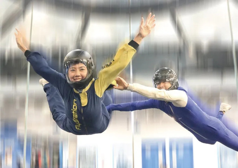 インストラクターと女性が屋内スカイダイビング