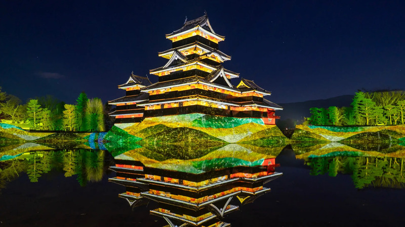 夜の松本城の美しい姿、水面反射、周囲の木々もライトアップ