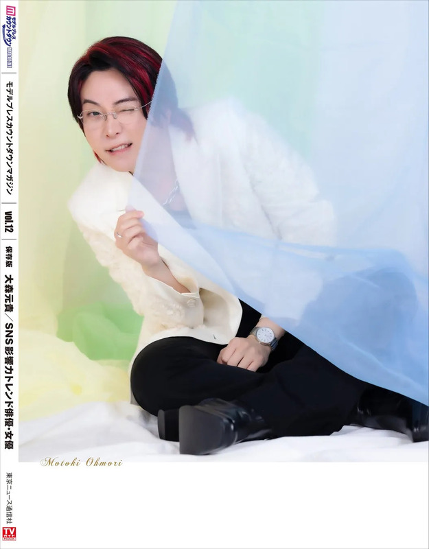 大森元貴が写った雑誌の表紙。水色の布の前に座り、ウィンクをしている。