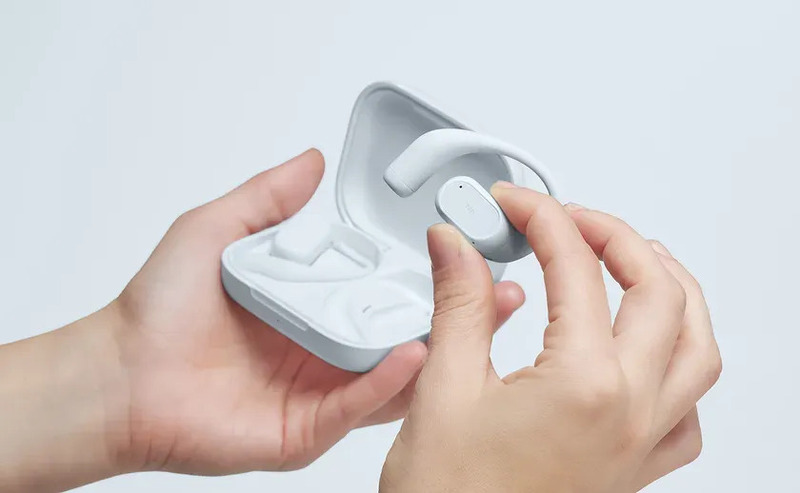 イヤホンとケースを持った手