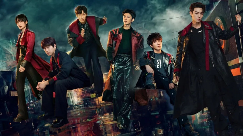 未来的なダークな衣装を身につけた6人の若い男性が、クールなポーズで集合している画像です。背景はサイバーパンク風の都市で、アイドルグループや俳優の宣材写真のようです。スタイリッシュで魅力的な雰囲気を醸し出しています。