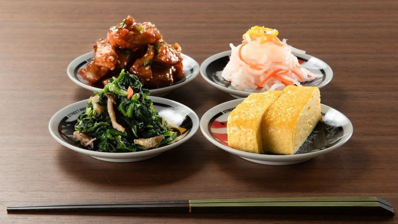 様々なおかずが乗った小皿が4つ並んだ写真です。箸も写っています。