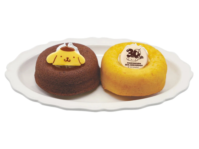 ポムポムプリンの30周年記念ケーキが2つ、白い皿に乗っている写真です。一つはチョコレートケーキでポムポムプリンの顔が飾られており、もう一つは黄色いケーキで30thのロゴが飾られています。