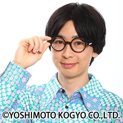 丸い眼鏡をかけた男性が眼鏡を触っている様子。