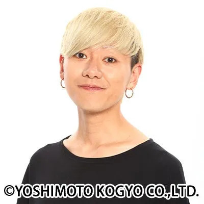 金髪の男性のポートレート写真。彼は黒いシャツを着ていて、笑顔を浮かべている。