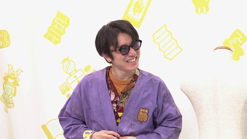 眼鏡をかけた男性が笑顔でカメラを見ている