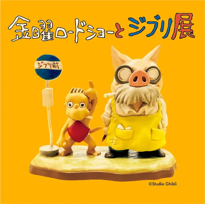 スタジオジブリの展示会の写真。展示物として、豚のキャラクターと、小さな黄色いキャラクターがバス停の前で立っている様子が写っています。背景は黄色です。