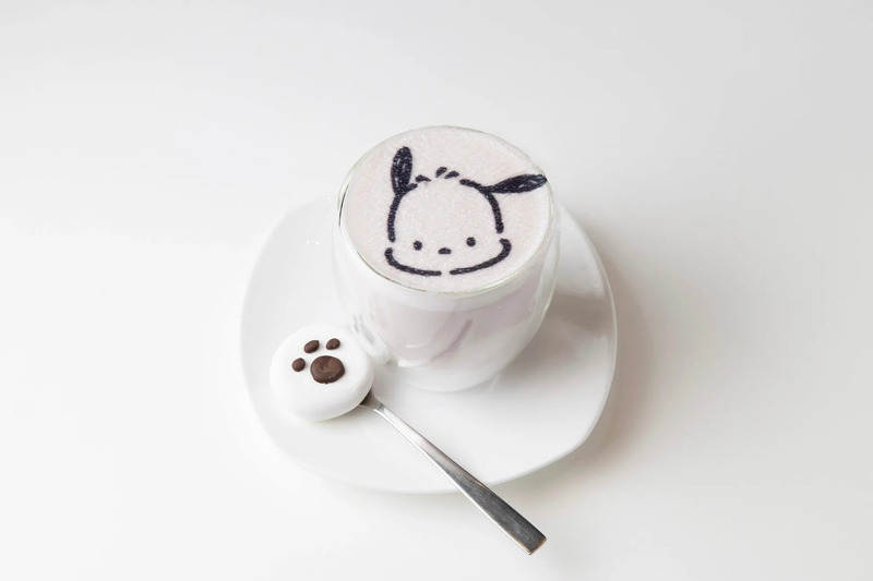 白い皿の上に、ポムポムプリンの顔が描かれたカフェラテと、足跡の形をしたマシュマロが乗っている写真です。