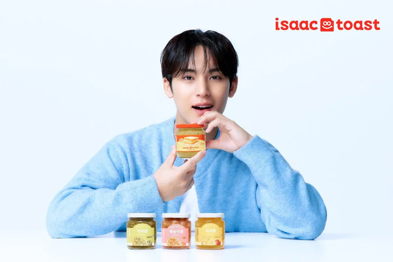 男性がisaac toastの瓶を持っており、isaac toastの他の瓶が3つ並んでいます。
