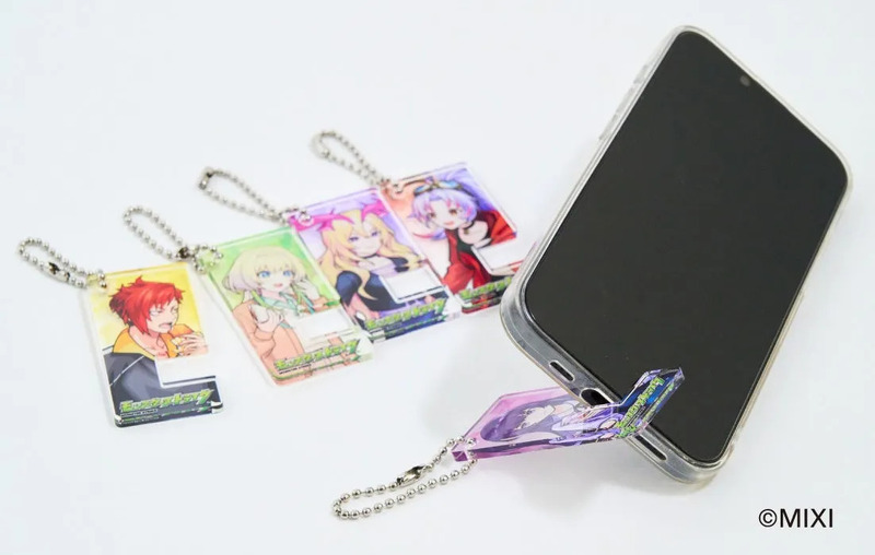 スマホに装着されたスタンドと、それに連なるキャラクターキーホルダーが写っている写真。キーホルダーにはアニメのキャラクターが描かれている。