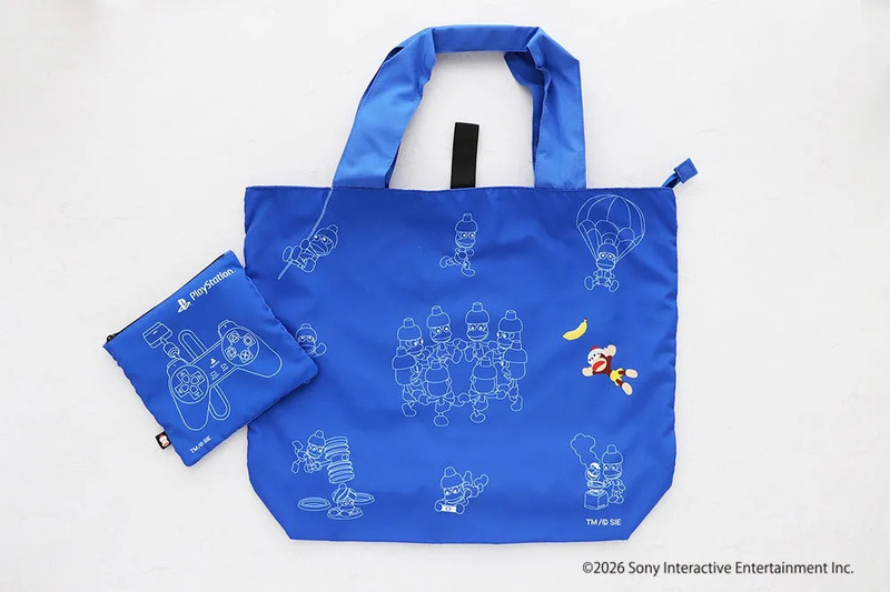 青色のトートバッグとポーチのセット。バッグにはゲームキャラクターのイラストが描かれ、ポーチにはPlayStationのロゴとコントローラーのデザインが施されている。