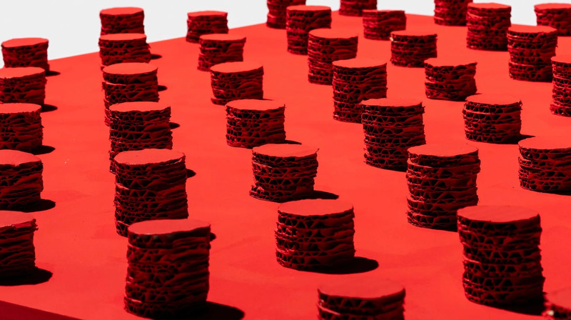 赤い背景に円柱状の造形物が複数配置された写真。