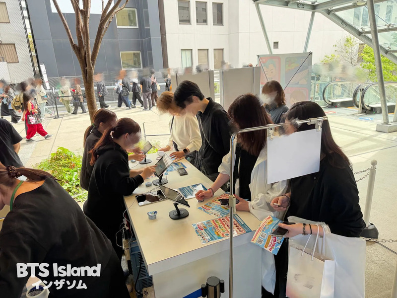 BTS Island インザソムのイベント会場の様子。多くの人がカウンターで手続きを行っている。