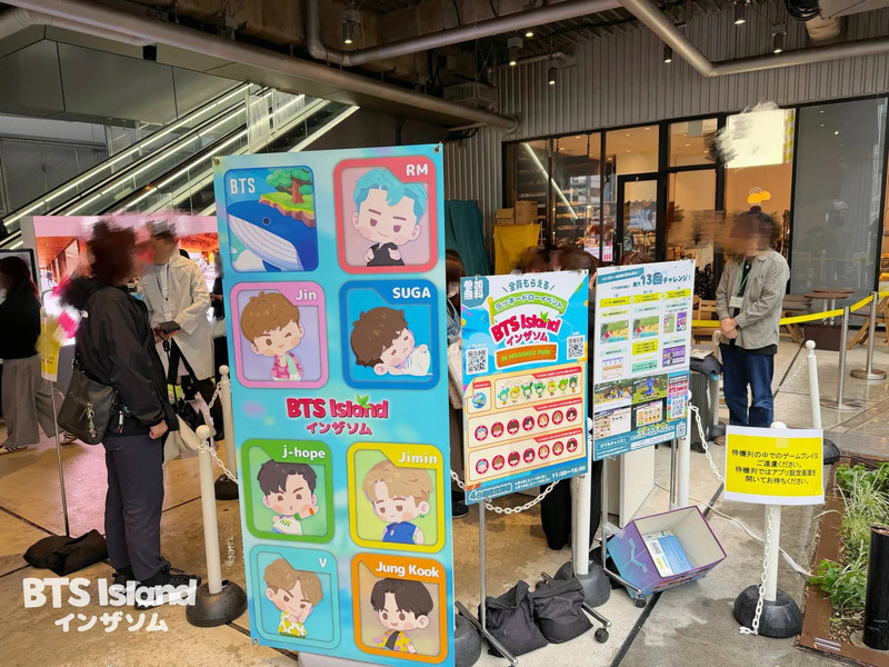 BTS Islandのイベント告知看板の写真。BTSのキャラクターイラストやイベント情報が掲載されている。