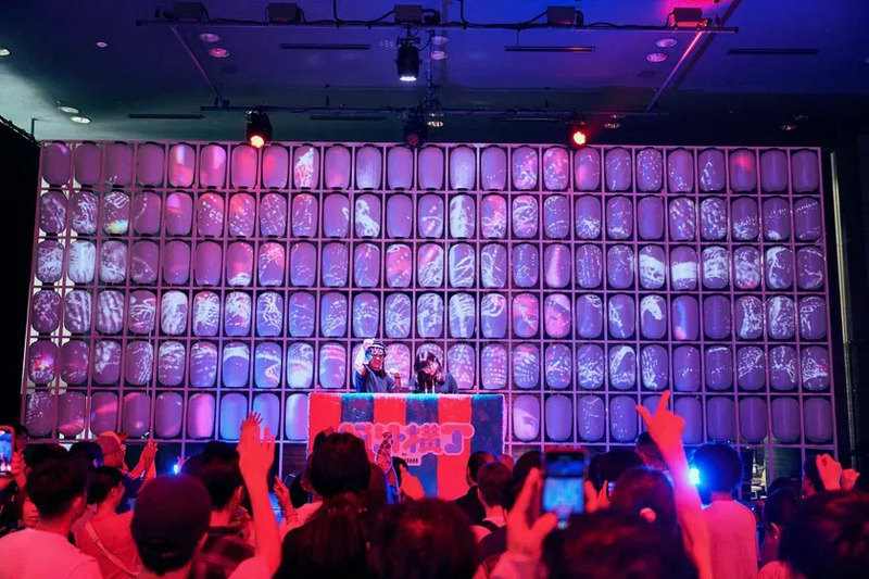 DJイベントの様子。提灯のようなものが並べられ、プロジェクションマッピングで模様が映し出されている。