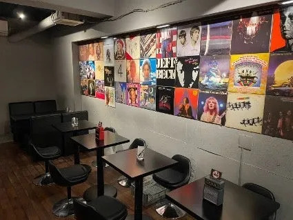 レコードジャケットが壁に飾られたバーの店内
