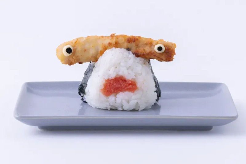 おにぎりがモンスターの顔のように見える写真。おにぎりの上には、揚げ物が目として配置されている。