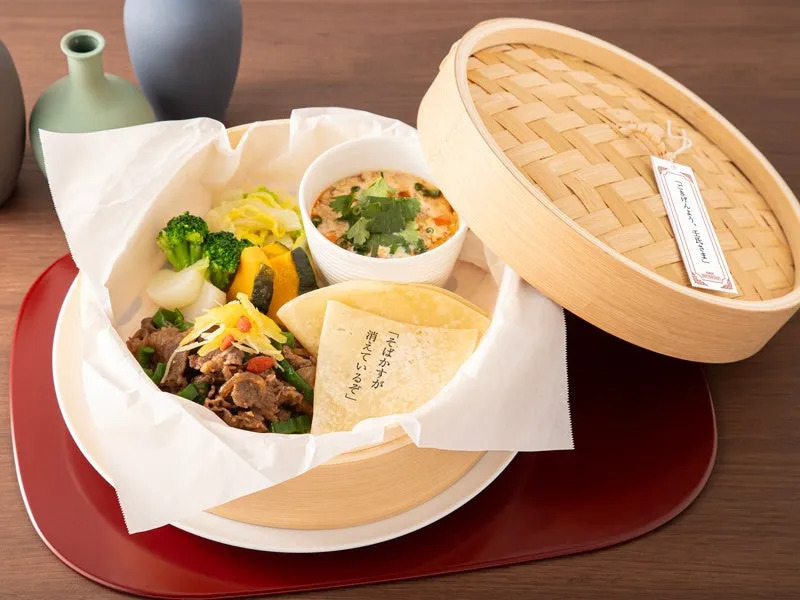 蒸籠に入った料理の写真。野菜や肉、スープ、クレープのようなものが入っている。そばかすが消えているぞと書かれた紙が添えられている。