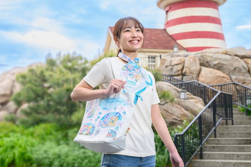 女性がトートバッグとスカーフを持っている